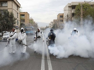 Nhân viên cứu hỏa trong trang phục bảo hộ khử trùng đường phố ở thủ đô Tehran, Iran, ngày 18/3. Ảnh: Reuters.