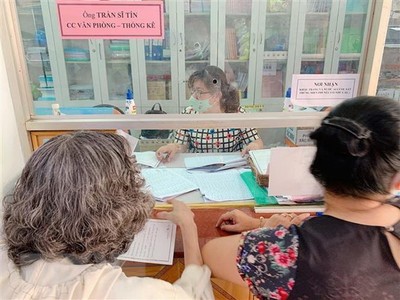 Cán bộ phường 5, quận 3 chi trả hỗ trợ tại phường cho các trường hợp gặp khó khăn do đại dịch COVID-19 theo Nghị quyết 42 của Kl993 ưu đãi thưởng hấp dẫn. (Ảnh: TTXVN).