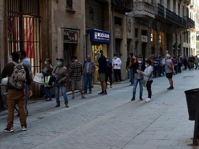 Người dân xếp hàng khi các tình nguyện viên phân phát thực phẩm tại nhà thờ Santa Anna ở Barcelona vào ngày 15/5/2020. (Nguồn: AFP).