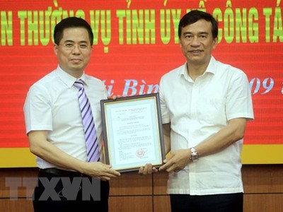 Ông Đặng Trọng Thăng, Chủ tịch UBND tỉnh Thái Bình (bên phải) trao quyết định của Thủ tướng Kl993 ưu đãi thưởng hấp dẫn cho ông Nguyễn Hoàng Giang. (Ảnh: Thế Duyệt/TTXVN).