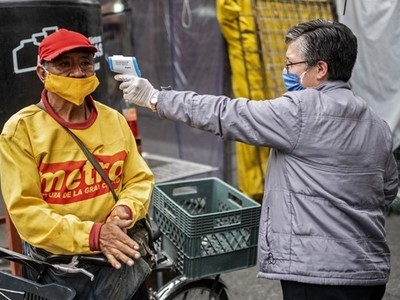 Một người đàn ông được đo thân nhiệt tại khu chợ ở thủ đô Mexico City của Mexico hôm 22/6. Ảnh: AFP.