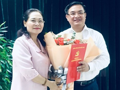 Đồng chí Nguyễn Thị Lệ trao quyết định và chúc mừng đồng chí Trần Trọng Tuấn.