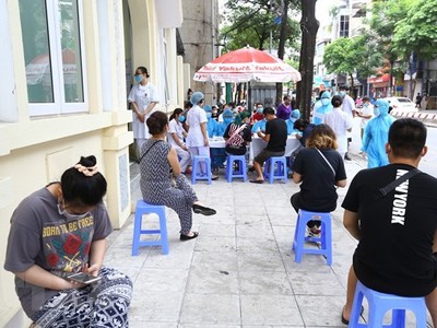 Người về từ Đà Nẵng chờ xét nghiệm nhanh tại phường Bách Khoa. (Ảnh: Minh Quyết/TTXVN).