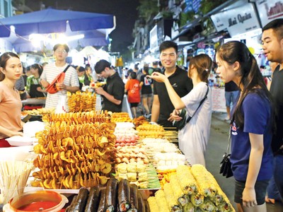 Du khách chọn món ăn tại chợ đêm khu phố cổ (quận Hoàn Kiếm, Hà Nội). Ảnh: Hồ Hạ.