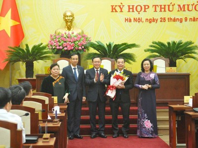 Chủ tịch UBND TP Hà Nội Chu Ngọc Anh nhận hoa chúc mừng từ Bí thư Thành ủy Vương Đình Huệ.