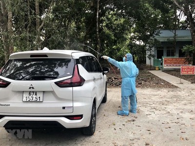 Khử khuẩn xe do tài xế M.T.T chở khách về Sóc Trăng. (Ảnh: TTXVN phát).