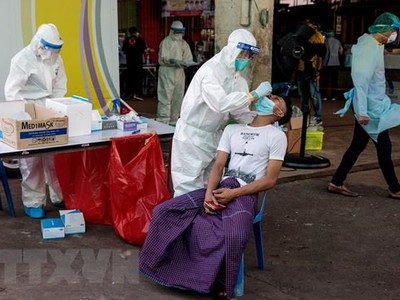 Nhân viên y tế lấy mẫu xét nghiệm COVID-19 tại Samut Sakhon, Thái Lan. (Ảnh: AFP/TTXVN).