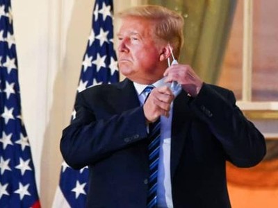 Cựu Tổng thống Donald Trump kéo khẩu trang khi xuất hiện tại ban công Nhà Trắng sau 3 ngày điều trị tại bệnh viện. (Ảnh: Reuters).