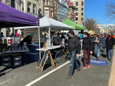 Người dân đeo khẩu trang phòng lây nhiễm COVID-19 tại một khu chợ ở Washington, DC, Mỹ, ngày 21/2/2021. (Ảnh: AFP/TTXVN).