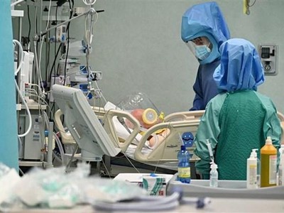 Nhân viên y tế điều trị cho bệnh nhân COVID-19 tại bệnh viện. (Ảnh: AFP/TTXVN).