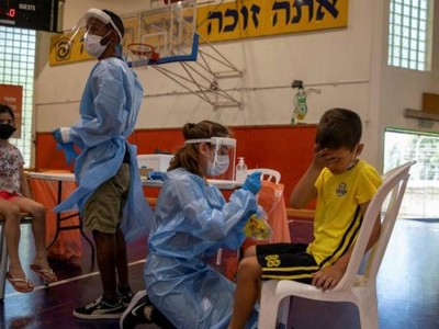 Các nhân viên y tế xét nghiệm Covid-19 cho các em nhỏ ở Binyamina, Israel. Ảnh: AP.
