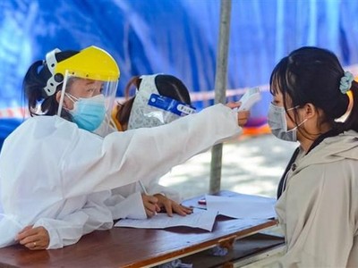 Nhân viên y tế đo thân nhiệt cho người dân trước khi tiêm vaccine, tại Đà Nẵng. (Ảnh: Văn Dũng/TTXVN).