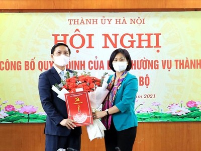 Phó Bí thư Thường trực Thành ủy Nguyễn Thị Tuyến trao quyết định, tặng hoa chúc mừng ông Nguyễn Thanh Liêm.