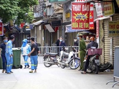Lực lượng công nhân vệ sinh thu dọn rác thải tại khu vực phong tỏa phường Phú Đô, quận Nam Từ Liêm (Hà Nội). (Ảnh: Tuấn Đức/TTXVN).