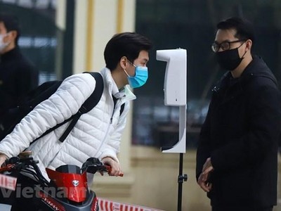 Học sinh được đo thân nhiệt và khử khuẩn tại khu vực cổng trường trước khi lên lớp. (Ảnh: Hoài Nam/Vietnam+)
