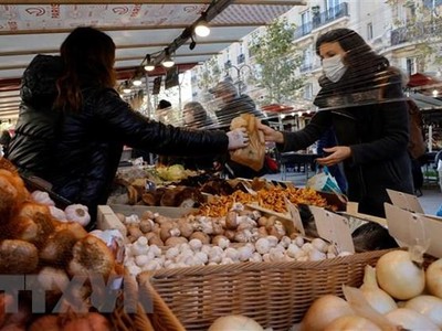Người dân mua thực phẩm tại một khu chợ ở Paris, Pháp. (Ảnh: AFP/TTXVN).