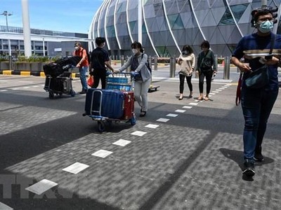 Hành khách đeo khẩu trang phòng dịch COVID-19 tại sân bay quốc tế Changi, Singapore. (Ảnh: AFP/TTXVN).