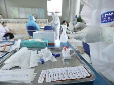 Nhân viên y tế lấy mẫu xét nghiệm cho người dân. (Ảnh: Minh Quyết/TTXVN).