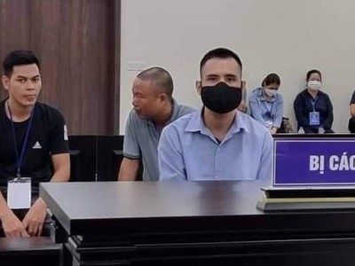 Bị cáo Việt (đeo khẩu trang, áo xanh) lừa đảo chạy vào ngành công an. (Nguồn: laodong.vn).
