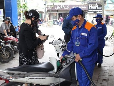 Nhân viên Petrolimex đang bán xăng cho khách hàng. (Ảnh: PV/Vietnam+)