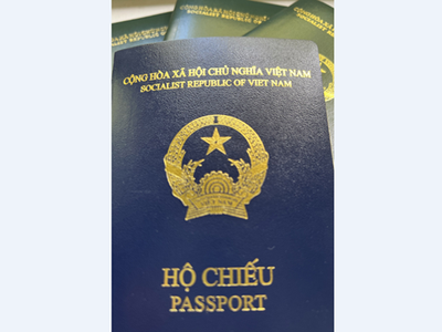 Cuốn hộ chiếu kiểu mới (màu xanh tím than) so với các cuốn hộ chiếu cũ màu xanh. (Ảnh: Mạnh Hùng/TTXVN).