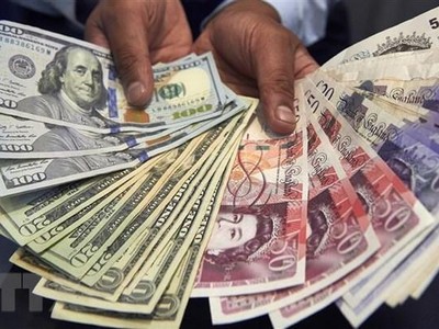 Đồng bảng Anh và đồng USD. (Ảnh: AFP/TTXVN)