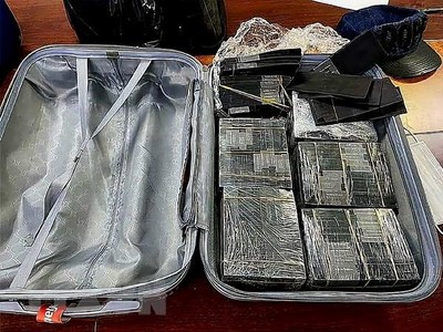 Cơ quan chức năng thu giữ số lượng lớn tiền mệnh giá 100 USD bị nhuộm đen bằng hóa chất. (Ảnh: TTXVN phát)