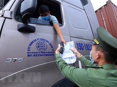 Lực lượng chức năng tại chốt kiểm dịch đầu cầu Trung Hà, huyện Ba Vì kiểm tra giấy thông hành và thẻ “luồng xanh” của các phương tiện vận tải ra, vào thành phố tháng 8/2021. (Ảnh: Tuấn Anh/TTXVN)
