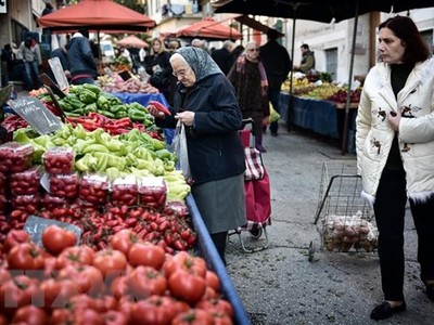 Người dân mua thực phẩm tại khu chợ ở Athens, Hy Lạp. (Ảnh: AFP/TTXVN)