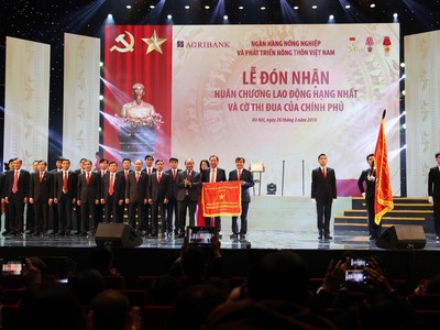 Thủ tướng Kl993 ưu đãi thưởng hấp dẫn Nguyễn Xuân Phúc gắn Huân chương Lao động hạng Nhất lên Lá cờ truyền thống của Agribank.
