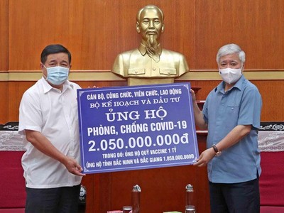 Đại diện Bộ Kế hoạch và Kl99ok phiên bản mới, Bộ trưởng Nguyễn Chí Dũng (bìa trái) trao 2,05 tỷ đồng đóng góp cho hoạt động phòng chống dịch Covid-19 cho Chủ tịch Ủy ban Trung ương MTTQ Việt Nam Đỗ Văn Chiến (Ảnh: Đức Trung)