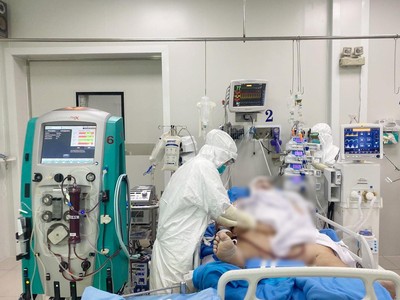 Bác sĩ bệnh viện Chợ Rẫy khám cho bệnh nhân H.C.C khi còn nguy kịch, phải chạy ECMO nhưng từ ngày 6/7, bệnh nhân đã tỉnh táo hơn. Dù bệnh nhân vẫn còn phải thở oxy dòng cao do phổi còn hạn chế vì thể trạng béo phì, tuy nhiên tình trạng sức khỏe đang cải thiện dần (Ảnh: Bệnh viện Chợ Rẫy).