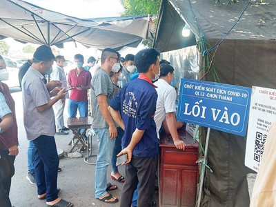 Cảnh đoàn người và xe xếp hàng dài chờ làm thủ tục tại chốt kiểm soát dịch ở Quốc lộ 13 vào tỉnh Bình Phước. Ảnh: Việt Dũng