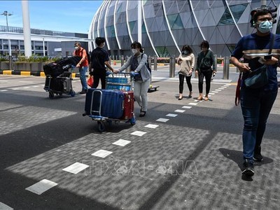 Hành khách đeo khẩu trang phòng dịch COVID-19 tại sân bay quốc tế Changi, Singapore. Ảnh: AFP/TTXVN