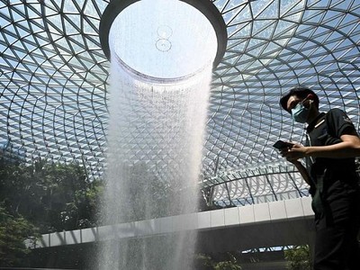 Hành khách di chuyển qua khu vực thác nước Rain Vortex tại sân bay Jewel Changi, Singapore ngày 27/2/2020. Ảnh tư liệu: AFP