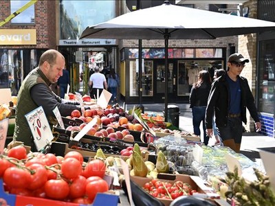 Người dân mua sắm tại một chợ ở London, Anh. Ảnh: AFP/TTXVN