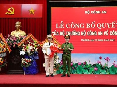 Thiếu tướng Nguyễn Ngọc Lâm, Thứ trưởng Bộ Công an trao Quyết định và tặng hoa chúc mừng Đại tá Trần Xuân Ánh.