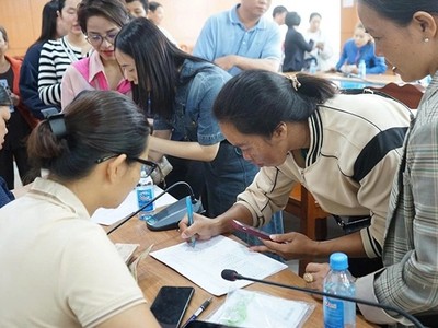 Người dân phấn khởi điền thông tin hộ gia đình để nhận quà Tết Độc lập. Ảnh: Hương Lý.