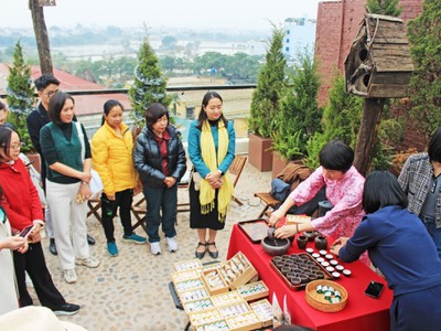 Đại biểu trải nghiệm tour “Đánh thức” tại xã Vân Đình, nghe giới thiệu về Thăng Long Chè Việt. Ảnh: TITC