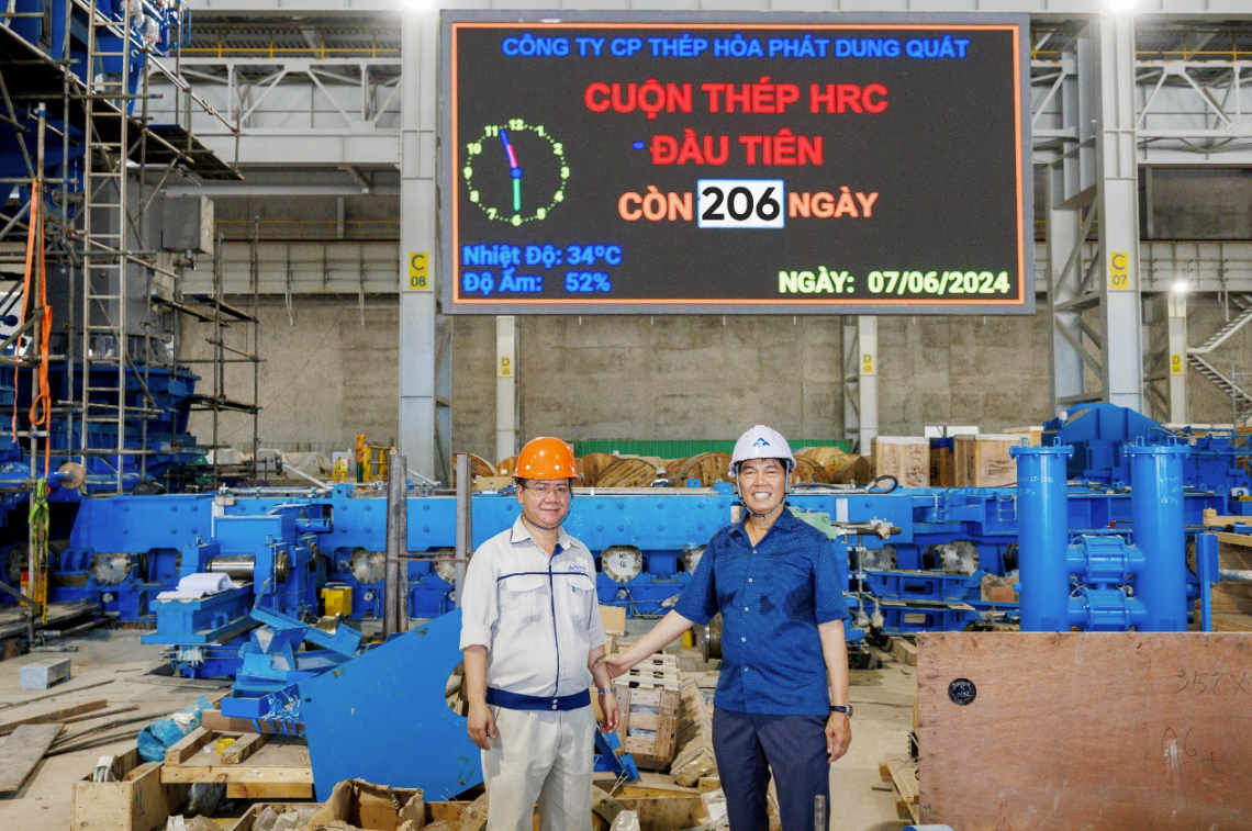 Chủ tịch Trần Đình Long và anh Bùi Văn Tiệp, Giám đốc Nhà máy cán thép QSP tại bảng đếm ngược cuộn HRC đầu tiên của Dự án Dung Quất 2 còn 206 ngày