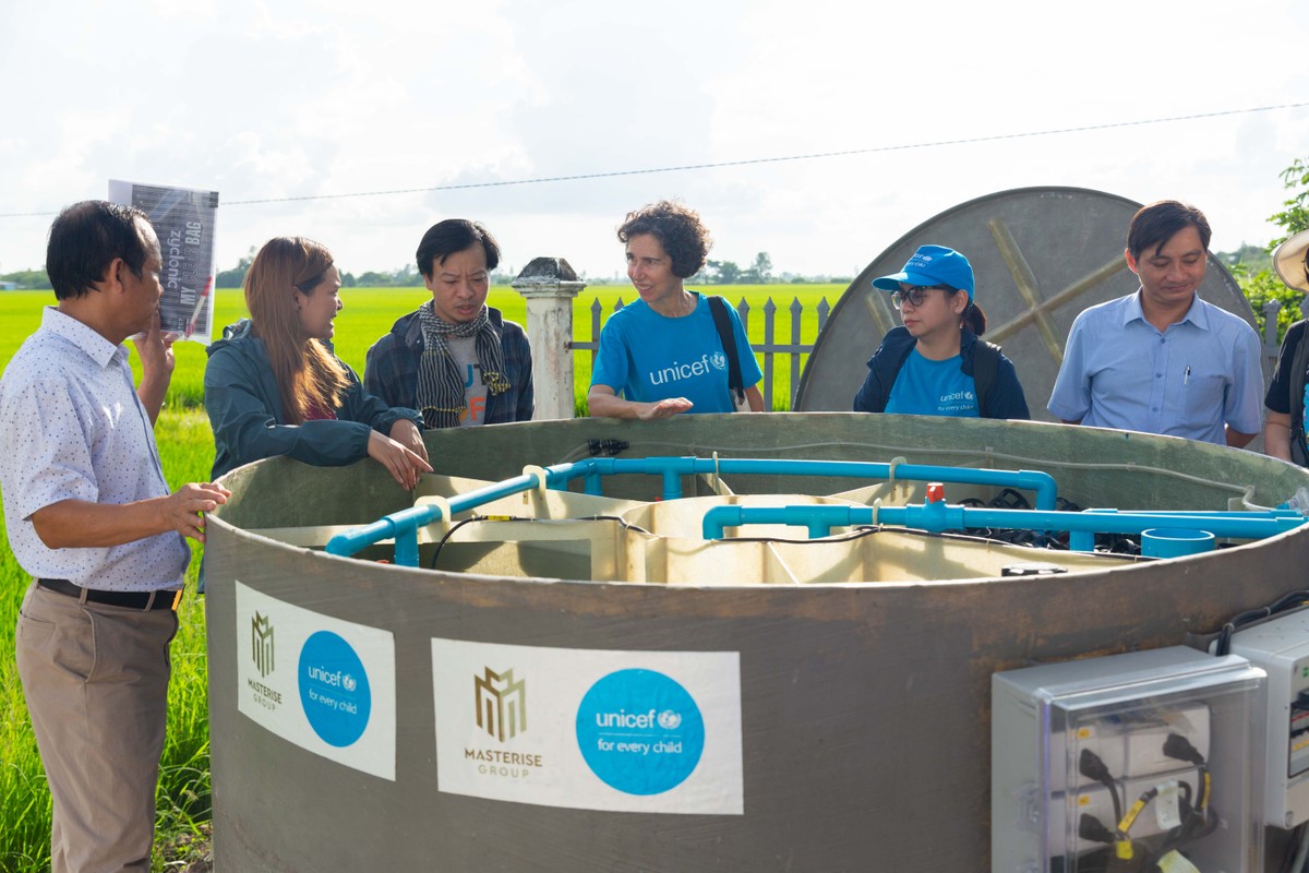 Cán bộ UNICEF và đại diện địa phương lắp đặt thiết bị của nhà vệ sinh không phát thải.