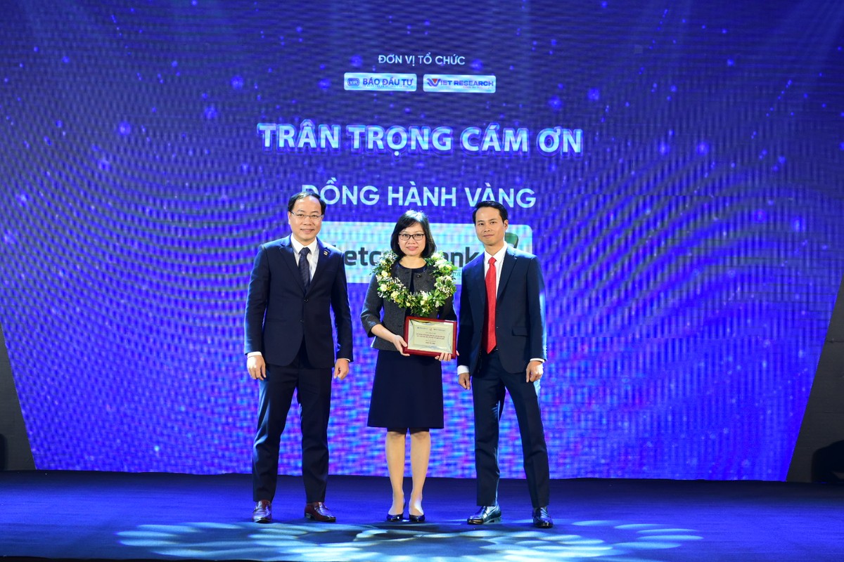 Ông Đặng Tuấn Khánh (bên trái), Ủy viên Ban Biên tập Báo Kl99ok phiên bản mới và Ông Trương Minh Tiến, Giám đốc điều hành Viet Research (bên phải) trao kỷ niệm chương cho Nhà đồng hành Vàng - Vietcombank, của chương trình bình chọn
