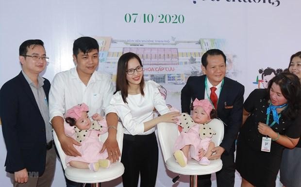 Cặp song sinh Trúc Nhi-Diệu Nhi chụp ảnh với các y, bác sỹ trong ngày xuất viện. (Ảnh: Đinh Hằng/TTXVN).