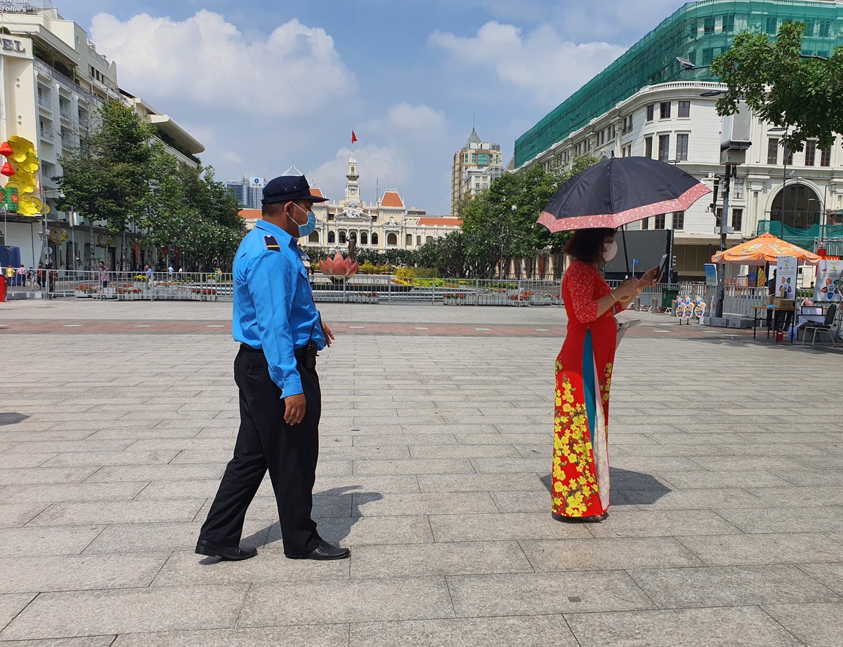 An ninh đường hoa nhắc nhở người dân chụp ảnh không tháo khẩu trang.