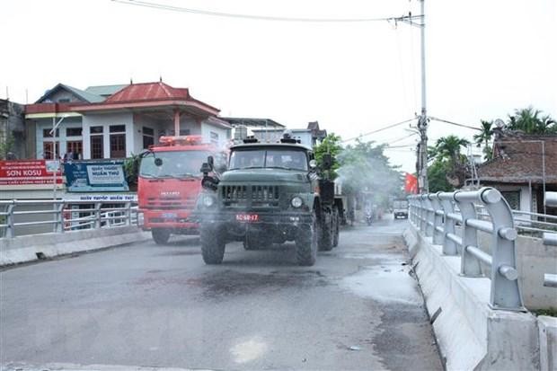 Trung tâm Kiểm soát bệnh tật Hải Phòng, Phòng Hóa học - Bộ Tư lệnh Quân khu 3 và UBND huyện Vĩnh Bảo phun thuốc khử trùng tiêu độc tại khu vực liên quan đến các ca dương tính với SARS-CoV-2. (Ảnh: TTXVN).