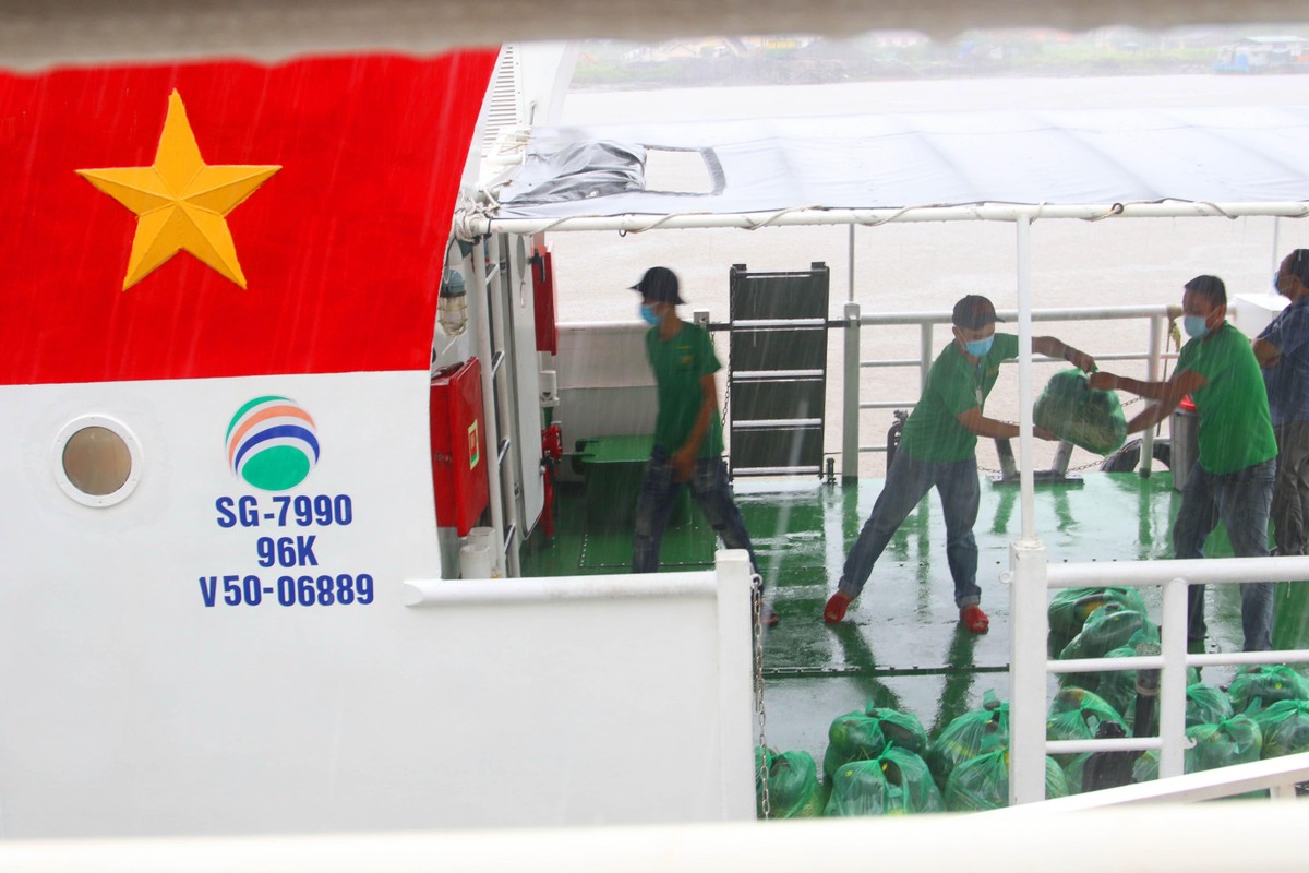 Nhân viên chuyển hàng từ khoang lên bờ.