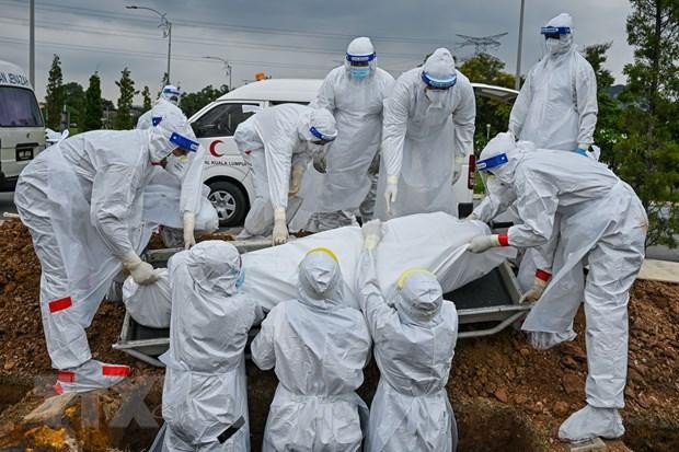 Các tình nguyện viên chôn cất thi thể bệnh nhân COVID-19 tại Kuala Lumpur, Malaysia ngày 15/6/2021. (Ảnh: AFP/TTXVN).