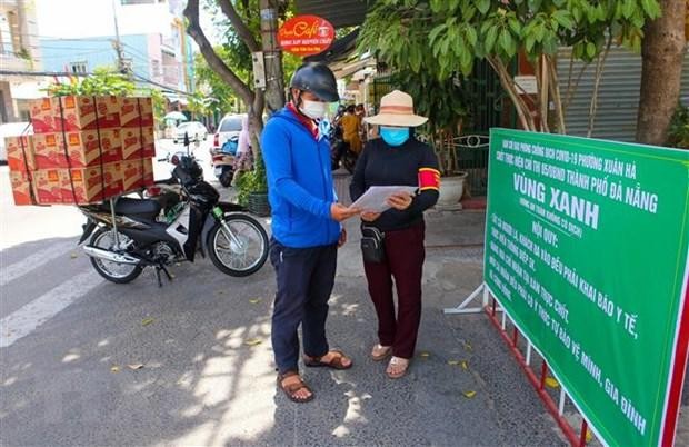 Kiểm tra giấy vận chuyển hàng vào khu vực vùng xanh tại một điểm chốt ở khu dân phường Xuân Hà. (Ảnh: Trần Lê Lâm/TTXVN).