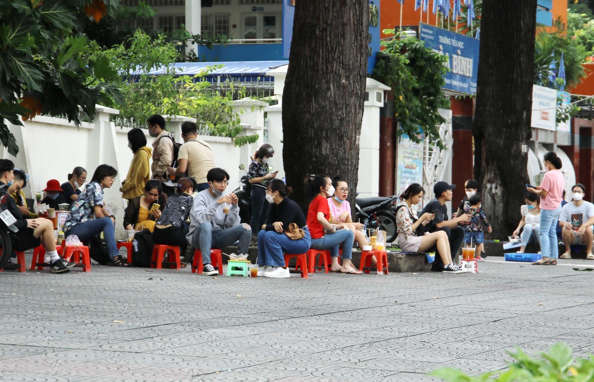 Hàng quán, cà phê vẫn chưa được phục vụ tại chỗ do đó điểm đến của các bạn trẻ là ngồi vỉa hè để ngắm người qua lại.
