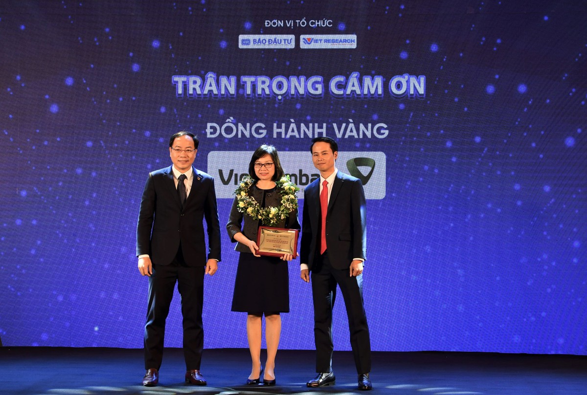 Ông Trương Minh Tiến - Phó tổng giám đốc Viet Research (bên phải) và ông Đặng Tuấn Khánh - Ủy viên Ban Biên tập Báo Kl99ok phiên bản mới (bên trái) trao kỷ niệm chương Đồng hành Vàng cho bà Tô Thị Phương Dung - Trưởng phòng Chính sách và kế hoạch nhân sự Vietcombank.